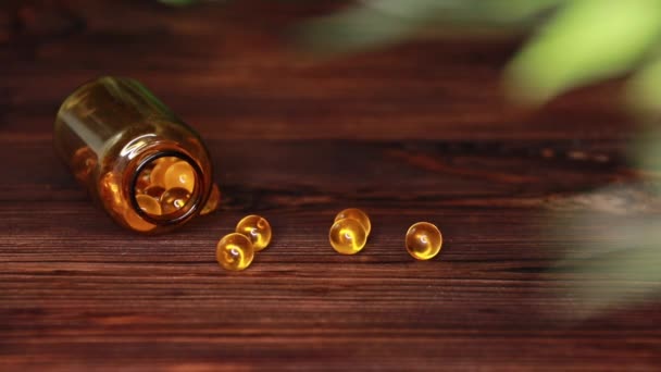 vitamíny doplňky pilulky omega 3 léky na olej z tresčích jater na dřevěném stolním rybím tuku - Záběry, video