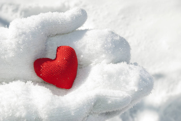 Female hands in mittens with a red heart, close-up. Place for text. - Photo, Image