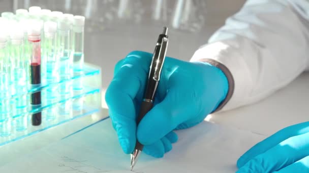 Orvos kezei a laborban. Jegyzetelés az antivírus vakcina kutatásához. - Felvétel, videó