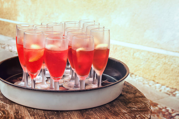fresh red cocktails, outdoor glasses on a tray placed on a wooden table  - Fotoğraf, Görsel