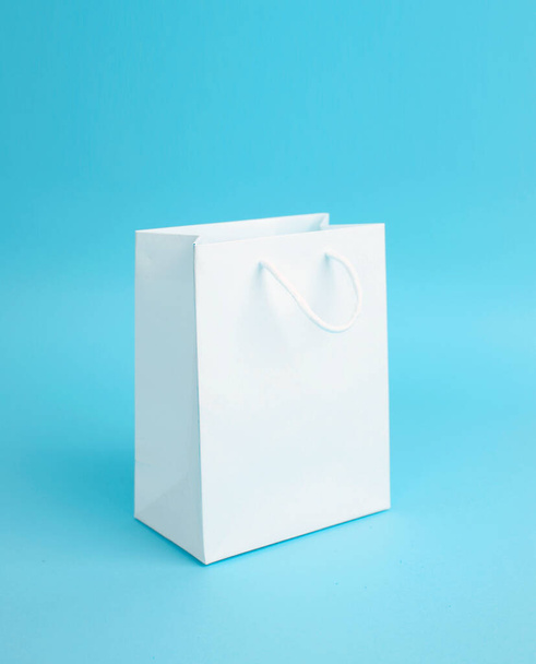 White empty paper bag on blue background. - Fotó, kép