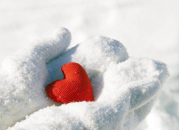 Γυναικεία χέρια σε γάντια με κόκκινη καρδιά, κοντινό πλάνο. Θέση για κείμενο. - Φωτογραφία, εικόνα