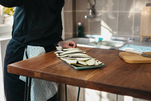 Female chef seasoning meal with eggplant - Valokuva, kuva
