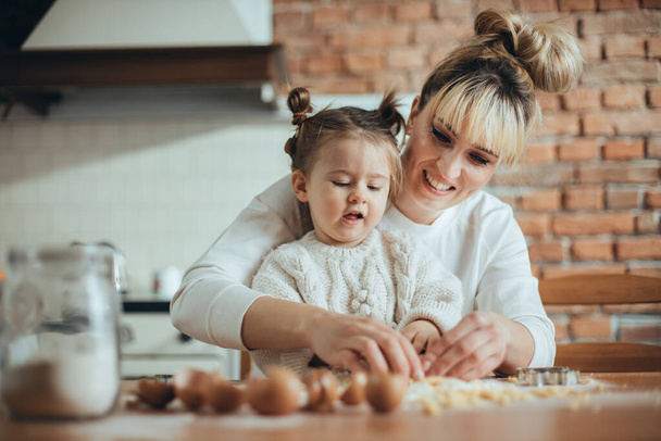 Mother and daughter baking cookies in their kitchen - Foto, immagini