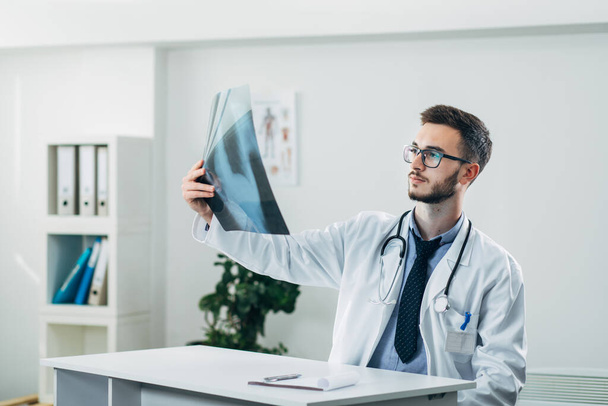 Doctor looking at x-ray in his office - Φωτογραφία, εικόνα