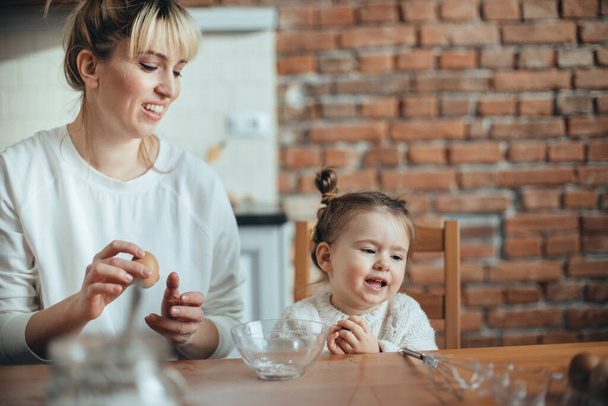 Mother and daughter baking cookies in their kitchen - Фото, зображення