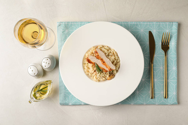 Delicious chicken risotto served on light grey table, flat lay - Fotografie, Obrázek