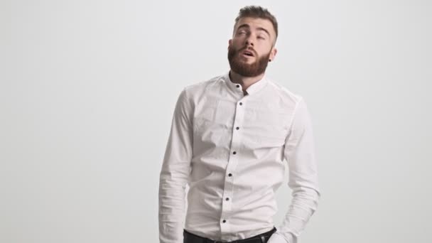 A disappointment bearded man is feeling exhausted and sad isolated over white wall background - Video