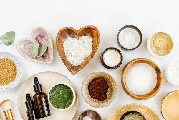 Beauty treatment ingredients for making homemade skin care cosmetic mask. Various bowl with clay, cream, essential oil and natural ingredients  on white table background. Organic spa cosmetic products - Foto, Imagen