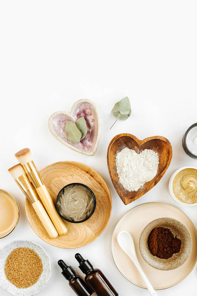 Beauty treatment ingredients for making homemade skin care cosmetic mask. Various bowl with clay, cream, essential oil and natural ingredients  on white table background. Organic spa cosmetic products - Photo, image