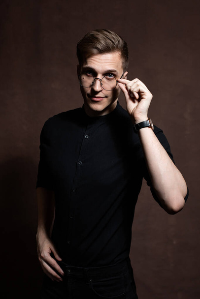 Man in round glasses and a black shirt. - Foto, afbeelding