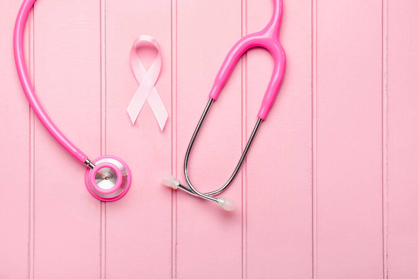 Pink ribbon with stethoscope on white wooden background. Breast cancer awareness concept - Zdjęcie, obraz