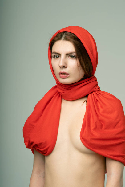 junges schönes Mädchen posiert in einem roten Schal im Studio - Foto, Bild