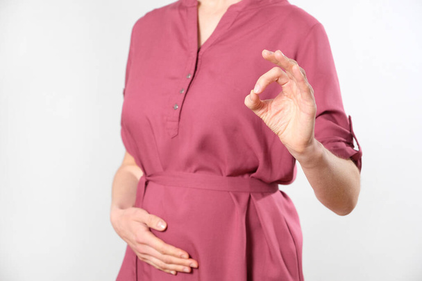 Pregnant woman shows consent gesture - Fotoğraf, Görsel