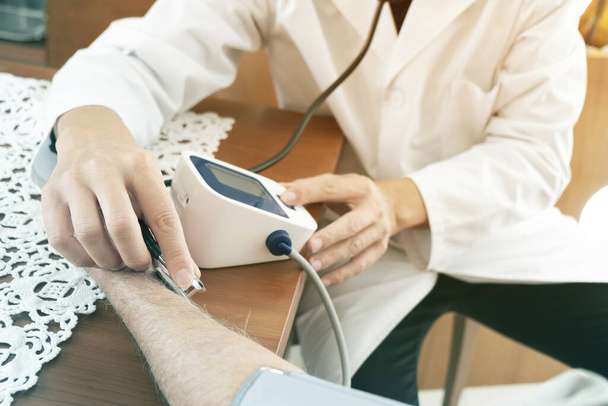 先輩の血圧を測定する医者 - 写真・画像