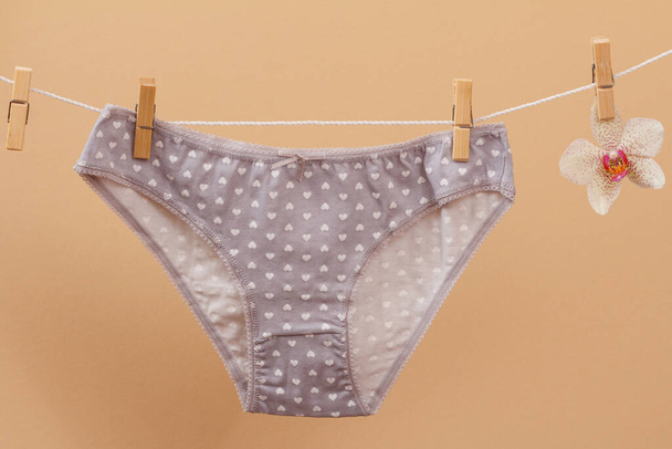Beautiful women's cotton panties on beige background. - Photo, image