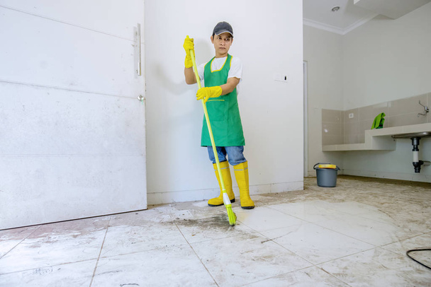 Male Asian worker cleaning the floor - Фото, изображение