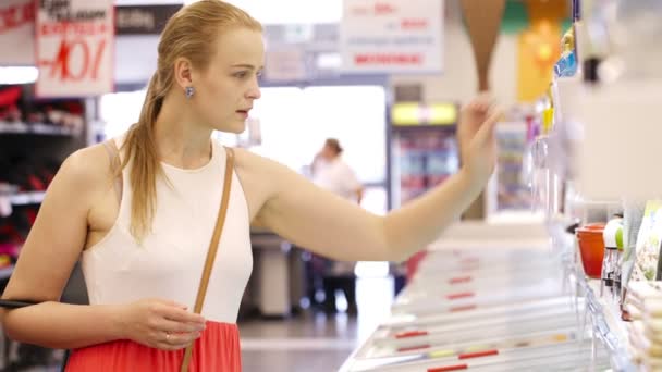 νεαρή ξανθιά γυναίκα που αγοράζουν τα προϊόντα στο σούπερ μάρκετ - Πλάνα, βίντεο