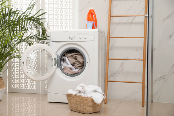 Modern washing machine with towels in bathroom - Foto, Bild
