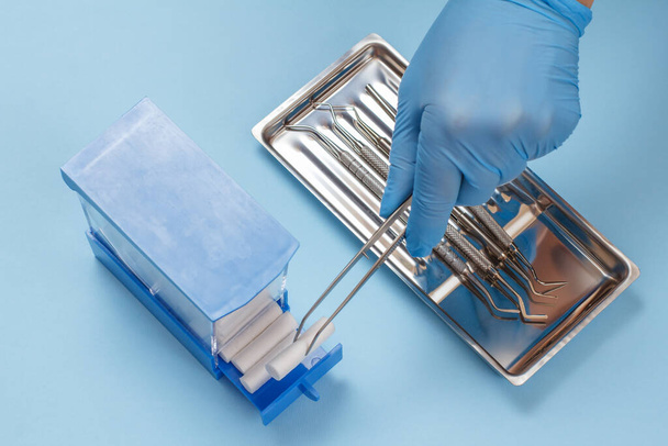 Hammaslääkärin käsi metallihammasinstrumenteilla hammashoitoa varten
 - Valokuva, kuva