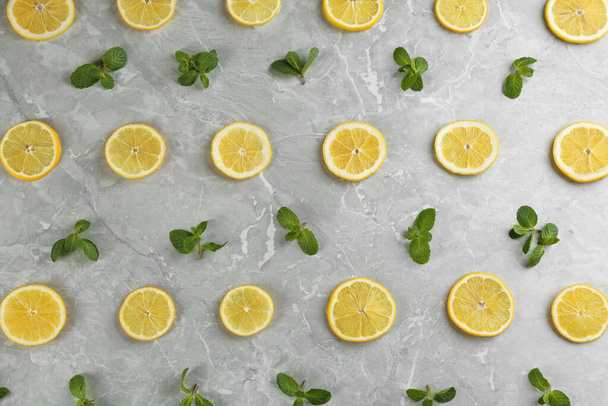 Lemonade layout with juicy lemon slices and mint on grey marble table, top view - Zdjęcie, obraz