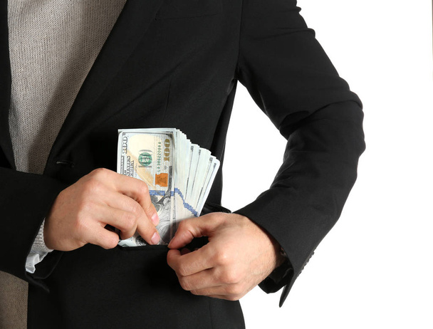 Man putting bribe money into pocket on white background, closeup - Valokuva, kuva