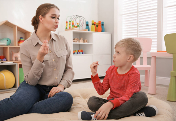 Speech therapist working with little boy in office - Foto, imagen