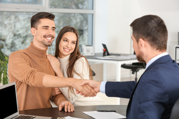Bank manager shaking hands with couple in office - Foto, Imagem