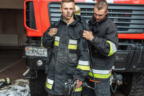 September 03, 2019, Ukraine Lviv city, young pretty and sexy firefighter sits by fire truck - Fotoğraf, Görsel