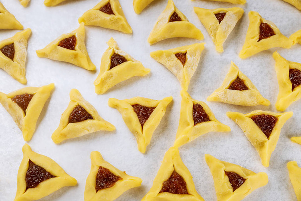 Raw hamantaschen jewish cookies with jam on oven tray. - Photo, Image