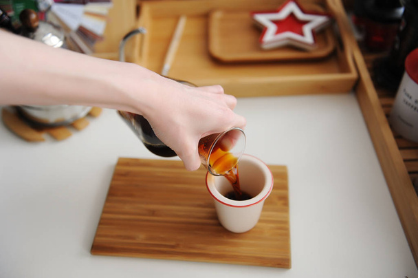 Elaboración manual de bodegones. Verter el café de filtro de decantador en la taza. Tablero de bambú. Tercera ola estética de la especialidad
 - Foto, Imagen