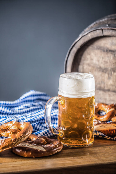 Oktoberfest large beer with pretzel wooden barrel and blue tablecloth - Fotografie, Obrázek
