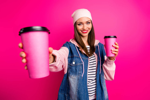 Close-up portrait of nice attractive lovely winsome cheerful cheery girl holding in hand coffee cups giving you new taste isolated on bright vivid shine vibrant pink fuchsia color background - Foto, Imagem