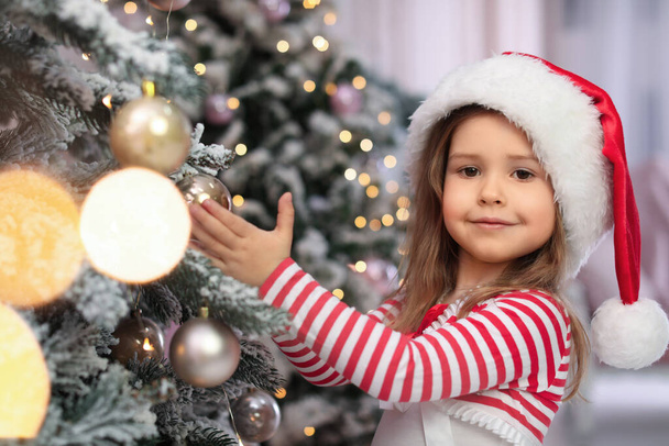 Cute little child near Christmas tree at home - Fotografie, Obrázek