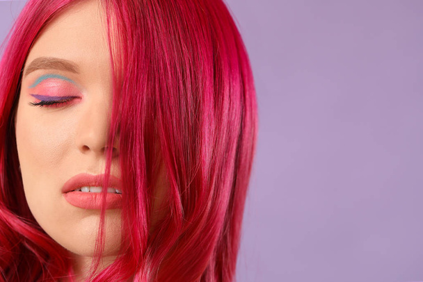 Schöne junge Frau mit ungewöhnlichen Haaren auf farbigem Hintergrund - Foto, Bild