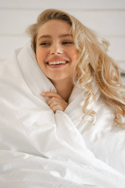 Positive delighted girl covering herself with blanket - Fotoğraf, Görsel
