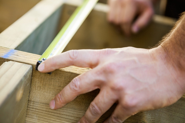 Carpenter's Hand Measuring Wood With Tape - Valokuva, kuva