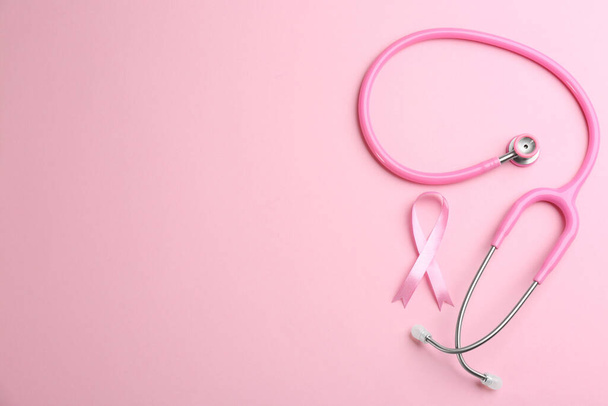 Pink ribbon and stethoscope on color background, flat lay with s - Photo, Image