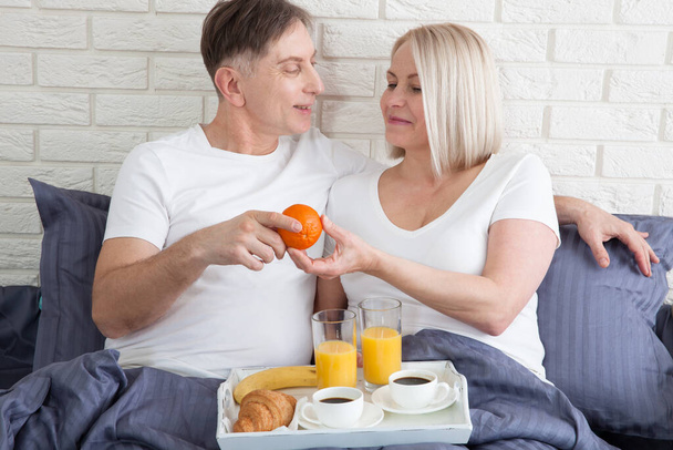 Good morning. Healthy breakfast in bed. Beautiful love couple is sitting in bed before having breakfast. - Foto, Bild