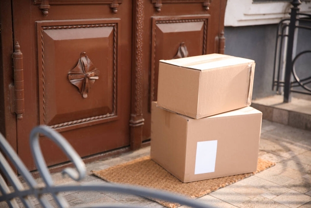 Delivered parcels on door mat near entrance - Foto, imagen