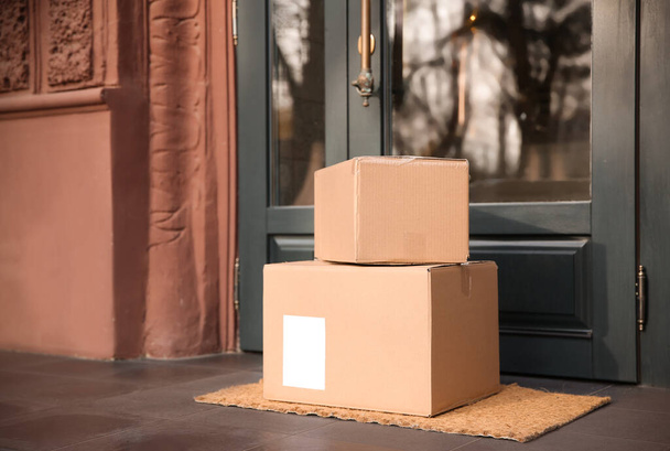 Delivered parcels on door mat near entrance - Foto, Imagen