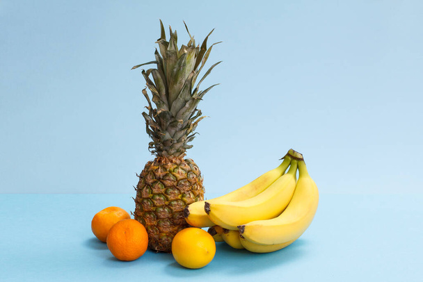 Φυσική σύνθεση από φρέσκα τροπικά φρούτα σε μπλε φόντο. - Φωτογραφία, εικόνα