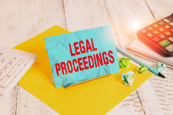 Text sign showing Legal Proceedings. Business photo text procedure instituted in a court of law to acquire benefit Notepaper stand on buffer wire in between computer keyboard and math sheets - Photo, Image
