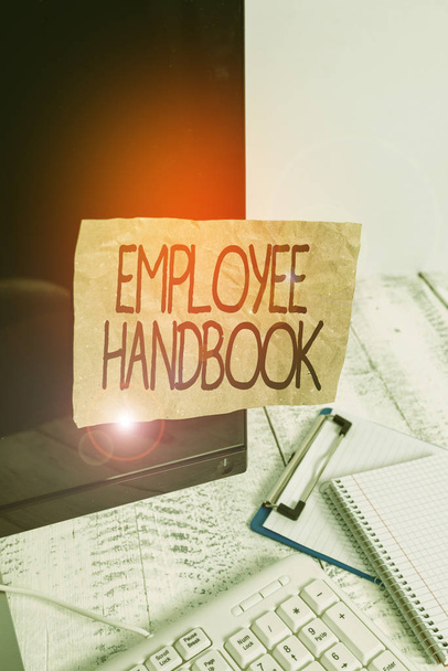 Conceptual hand writing showing Employee Handbook. Concept meaning states the rules and regulations and policies of a company Note paper taped to black screen near keyboard stationary - Photo, Image