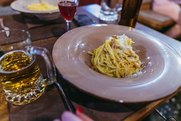 Carbonara paste. A man eats an Italian dish of pasta carbonara - Zdjęcie, obraz