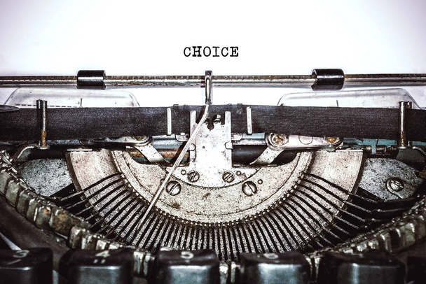 Oude vintage typemachine, retro machine met wit vel papier en getypte tekst "choice", kopieerruimte, close up - Foto, afbeelding