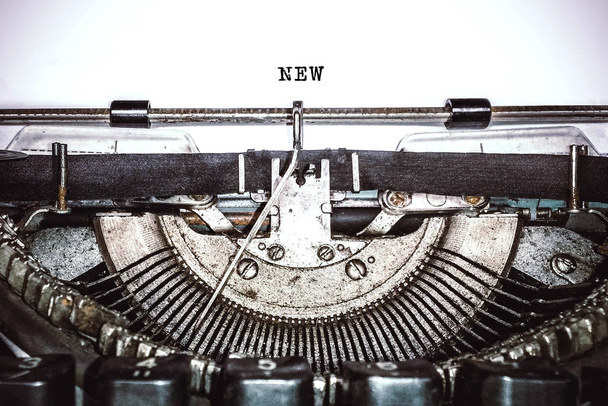 Old vintage typewriter, retro machine with white sheet of paper and typed text "new", copy space, close up - Fotoğraf, Görsel