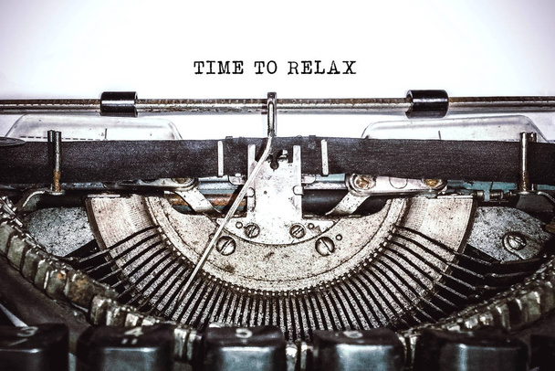 Old vintage typewriter, retro machine with white sheet of paper and typed text "time for relax", copy space, close up - 写真・画像