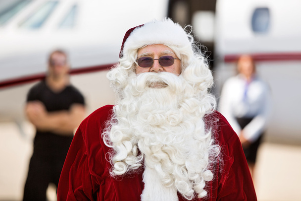 Santa Standing Against Private Jet - Photo, Image