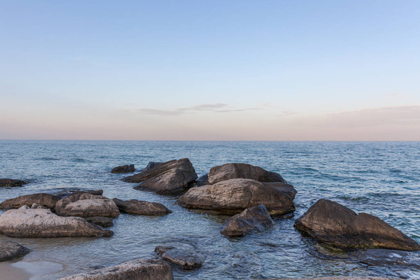 View of blue sea waves at rocky beach. Horizon line. Caspian Sea, sandstone coast. ustyurt. Selective focus, long shutter speed - Foto, afbeelding